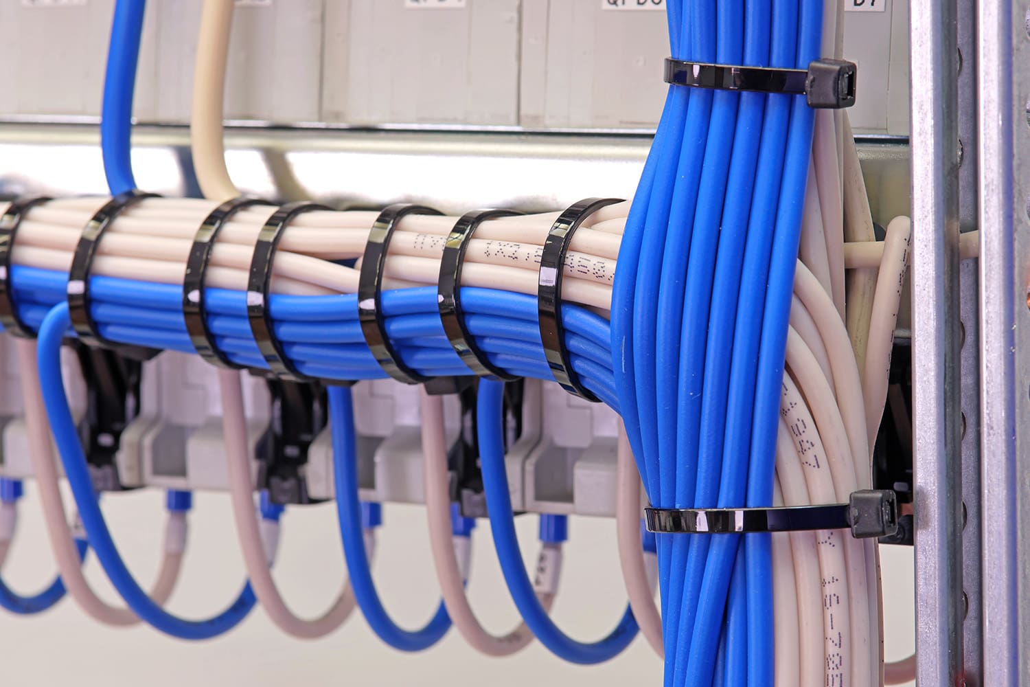 A cluster of blue and white wires organized and grouped together by color, and then zip tied.